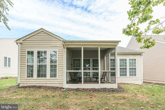 rear view of property with a sunroom, a lawn, and a patio