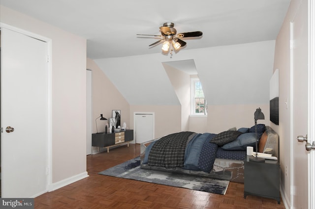 bedroom with ceiling fan, dark parquet floors, and lofted ceiling