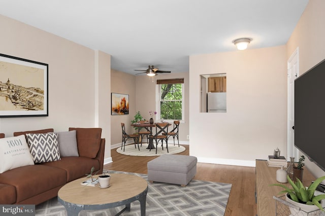 living room featuring ceiling fan and wood-type flooring