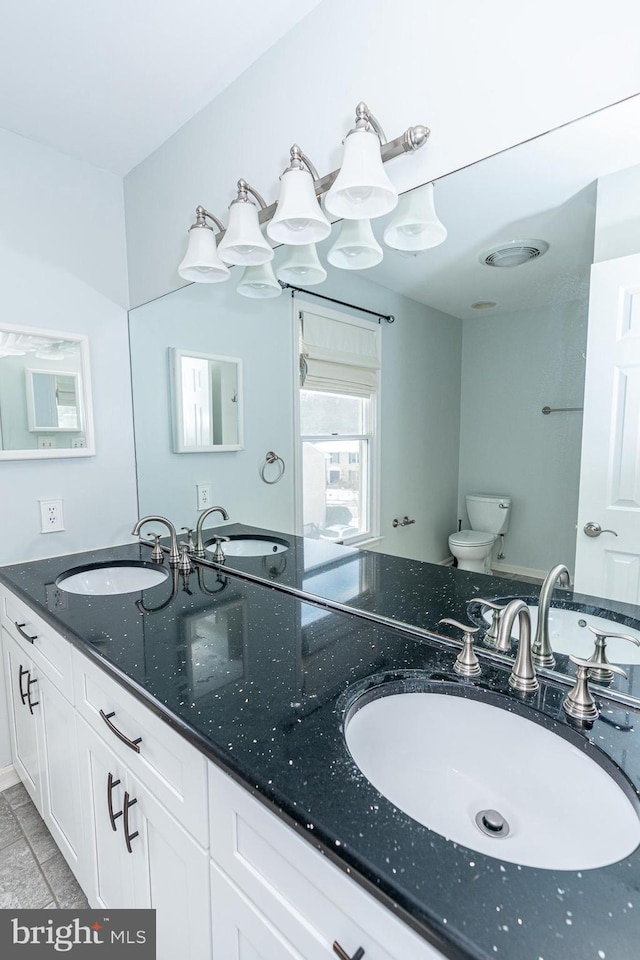 bathroom featuring toilet, vanity, and tile patterned flooring