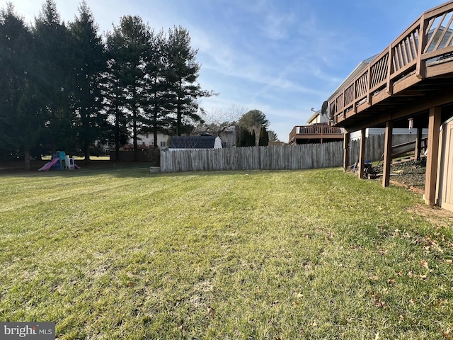 view of yard featuring a wooden deck and a playground