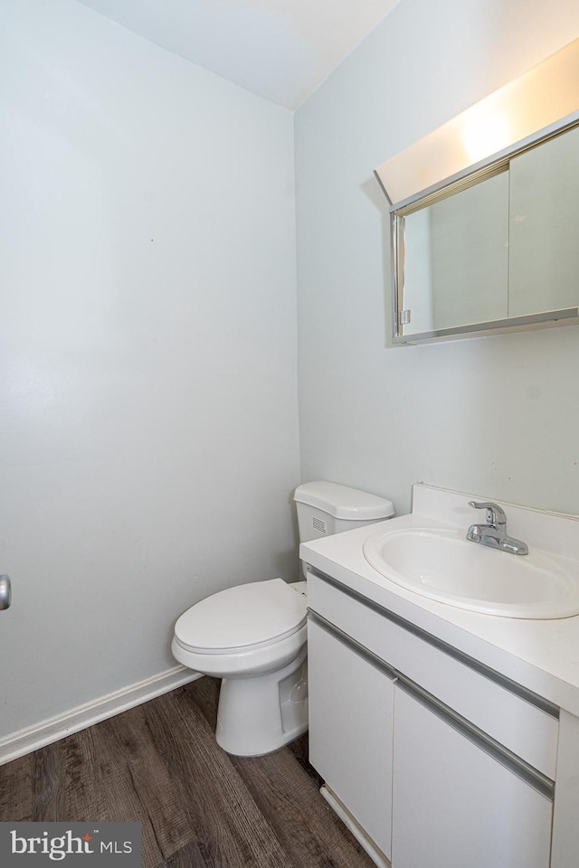 bathroom featuring toilet, wood-type flooring, and vanity