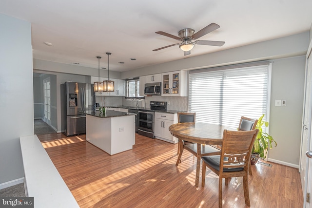 dining space featuring light wood-type flooring and ceiling fan