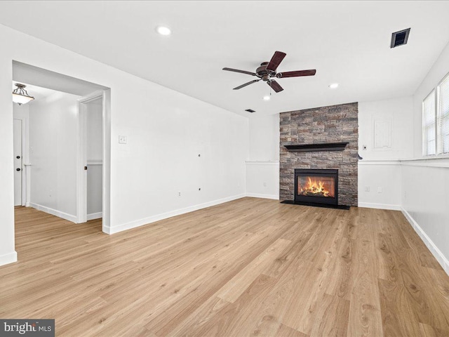 unfurnished living room featuring ceiling fan, light wood-type flooring, and a fireplace