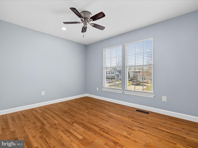 spare room with hardwood / wood-style floors and ceiling fan