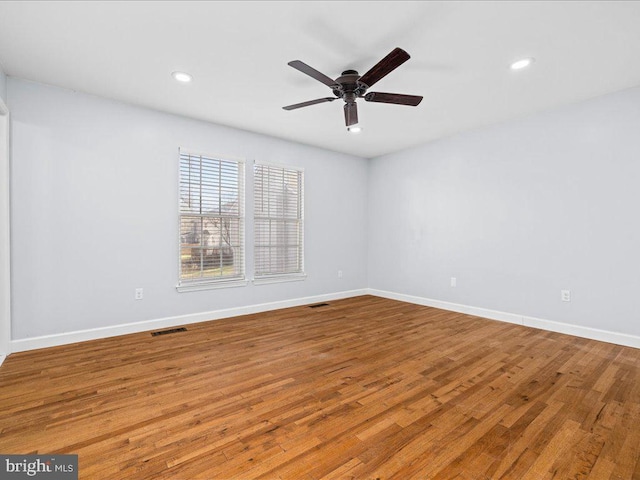 spare room with ceiling fan and light wood-type flooring