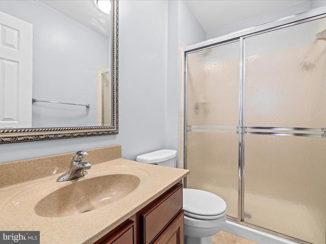 bathroom with toilet, an enclosed shower, and vanity