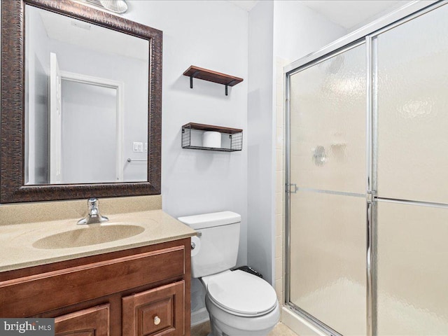 bathroom featuring vanity, toilet, and a shower with door