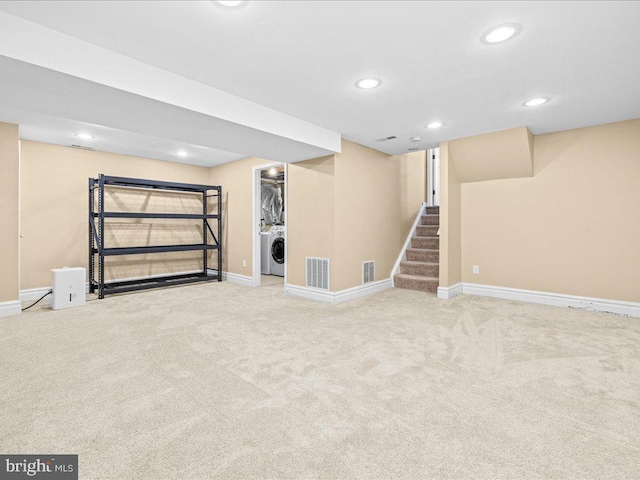 basement featuring washer / dryer and light colored carpet