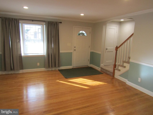 foyer entrance with hardwood / wood-style flooring and crown molding