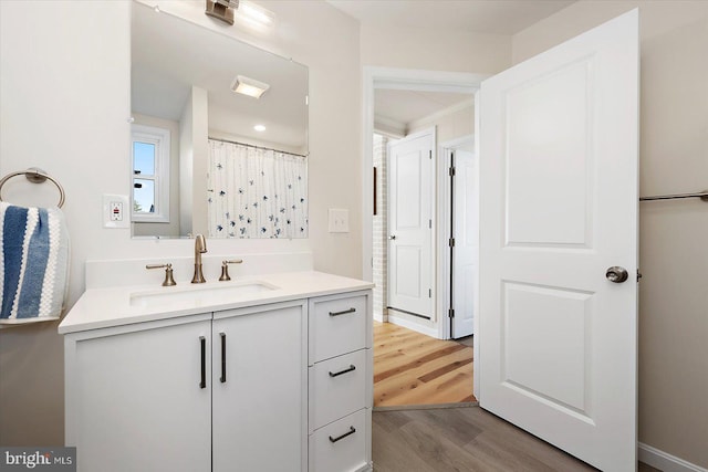 bathroom with vanity, wood-type flooring, and curtained shower