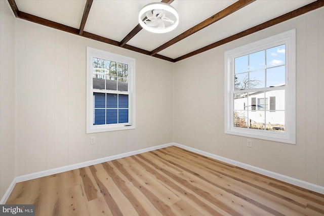 unfurnished room featuring beam ceiling and light wood-type flooring