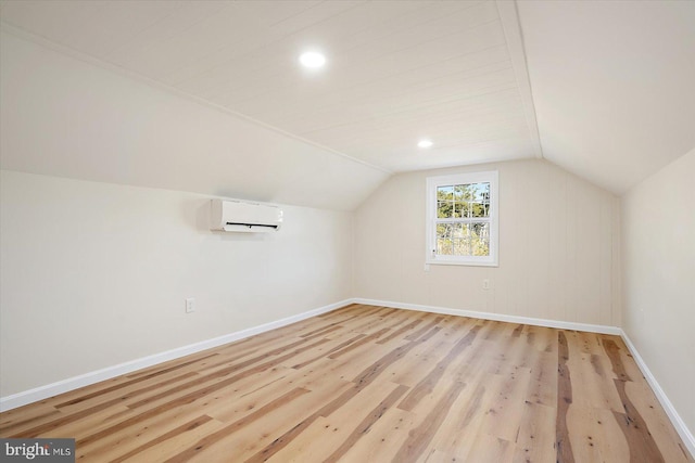 bonus room with light wood-type flooring, lofted ceiling, and a wall mounted air conditioner