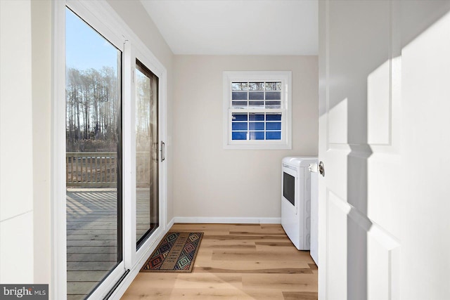 laundry area with light hardwood / wood-style flooring and washing machine and clothes dryer