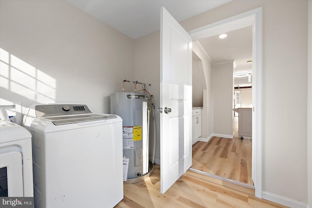 laundry area featuring electric water heater, washing machine and dryer, and light hardwood / wood-style floors