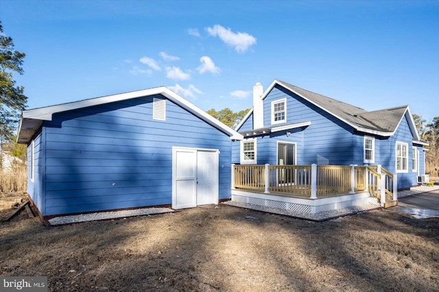 rear view of house featuring a wooden deck