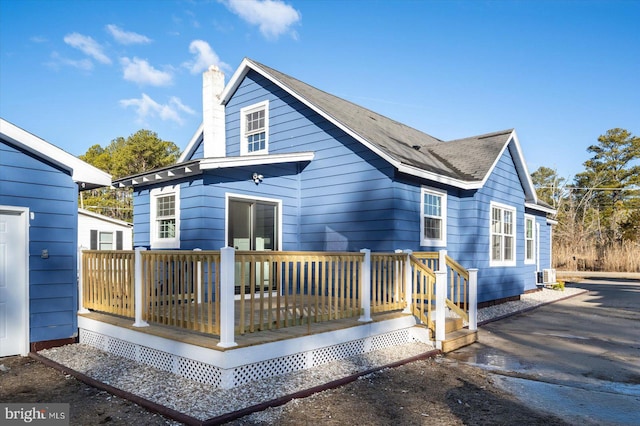 back of property with a wooden deck and central AC