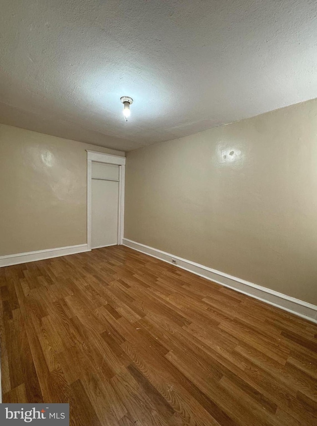 basement with wood-type flooring and a textured ceiling