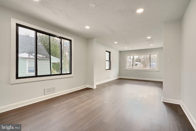 empty room featuring a textured ceiling and dark hardwood / wood-style flooring