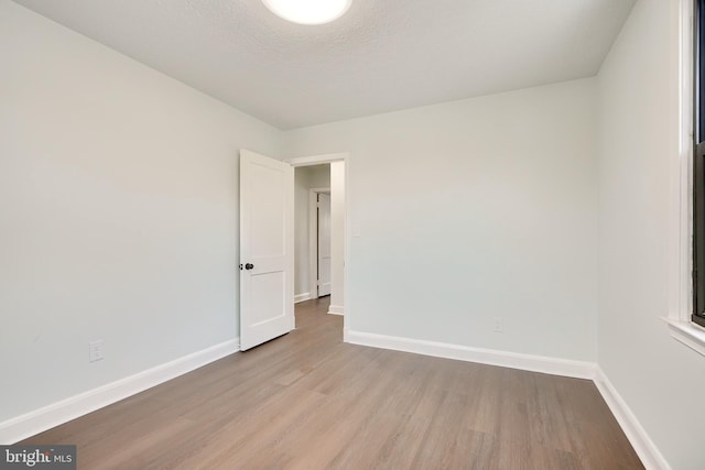 empty room featuring a textured ceiling and light wood-type flooring