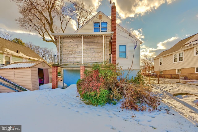 view of snowy exterior featuring a storage unit