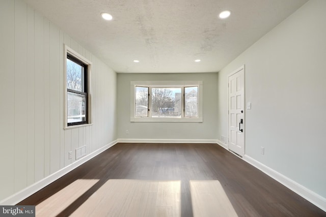 empty room featuring dark wood-type flooring and a textured ceiling