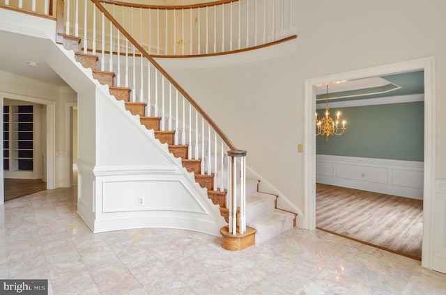 stairs with a notable chandelier and crown molding