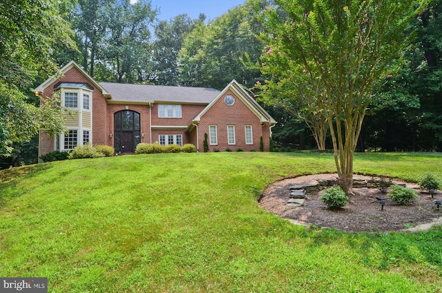 view of front of home with a front lawn and brick siding