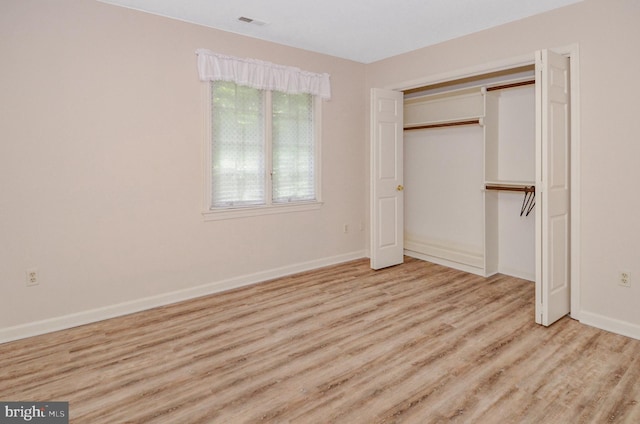 unfurnished bedroom featuring light hardwood / wood-style floors and a closet