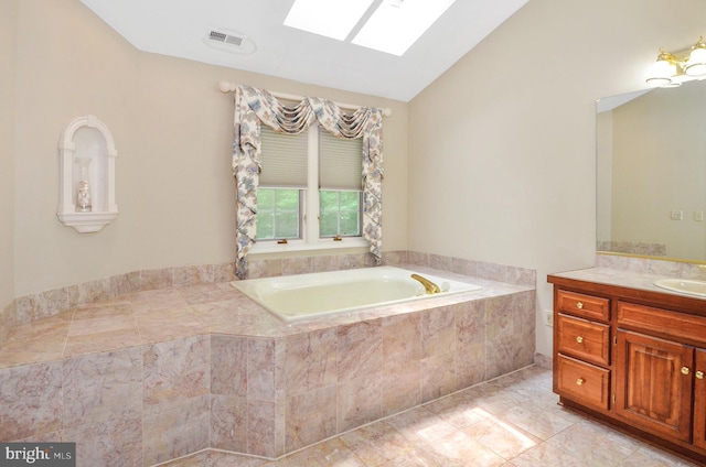 full bath with lofted ceiling with skylight, a garden tub, vanity, and visible vents