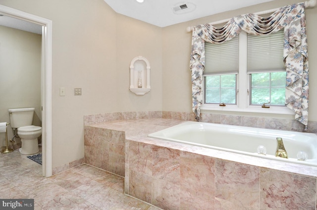 bathroom with a relaxing tiled tub and toilet