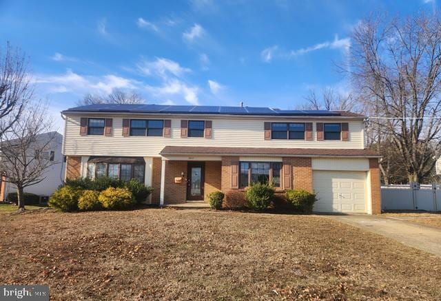 view of front of property featuring solar panels and a garage