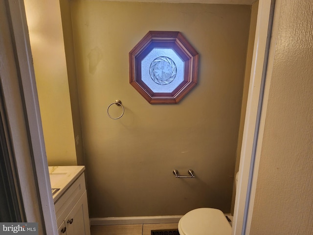 bathroom featuring tile patterned floors, vanity, and toilet