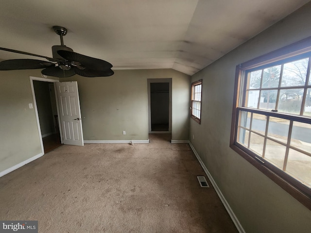 spare room featuring light colored carpet, ceiling fan, and lofted ceiling