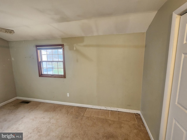 unfurnished room with carpet and lofted ceiling