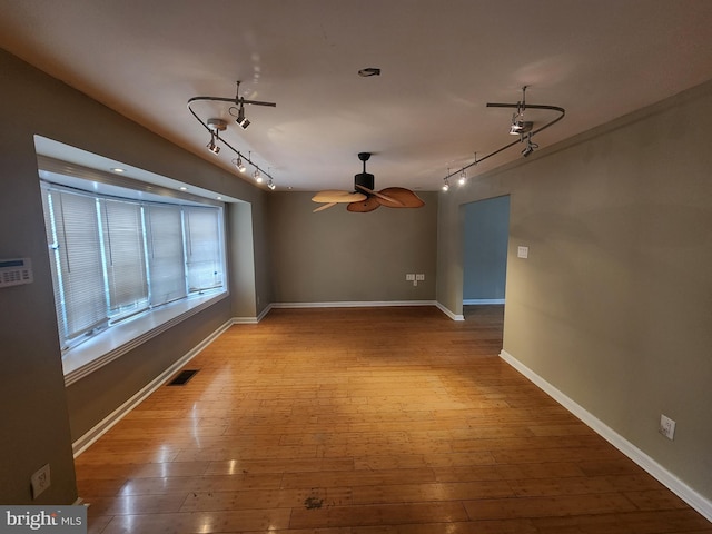 spare room featuring light wood-type flooring, rail lighting, and ceiling fan