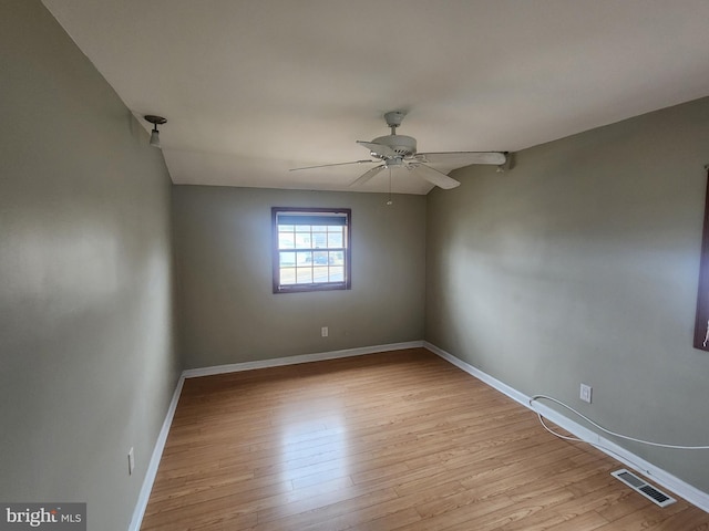 empty room featuring light wood-type flooring, vaulted ceiling, and ceiling fan