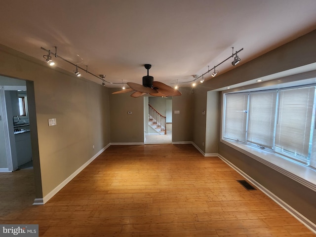 unfurnished room with light wood-type flooring, track lighting, and ceiling fan