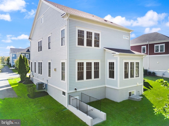 back of house featuring a yard and central AC