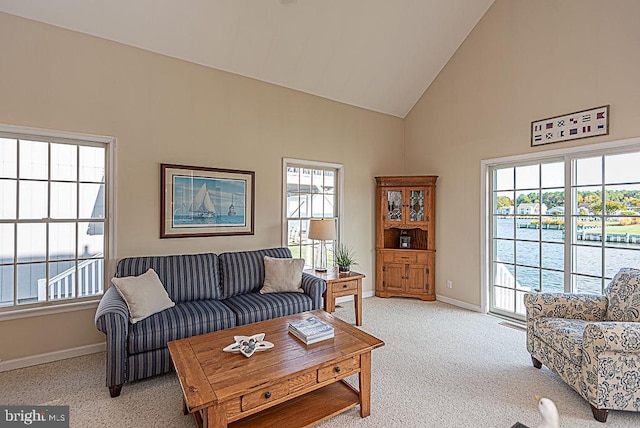 carpeted living room featuring high vaulted ceiling