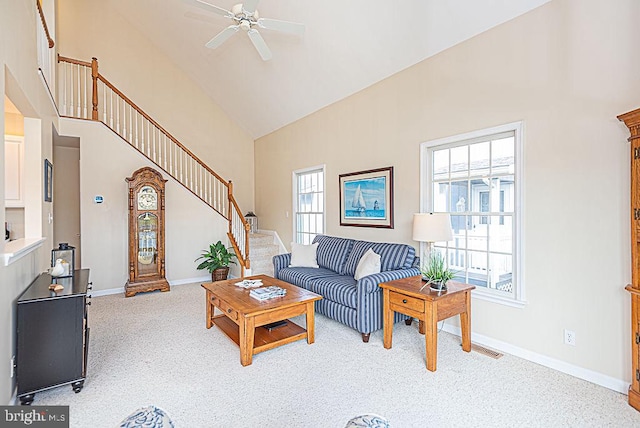 carpeted living room with a healthy amount of sunlight, high vaulted ceiling, and ceiling fan