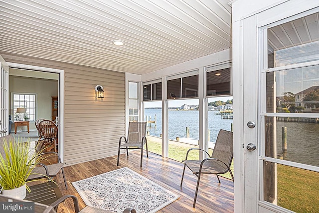 sunroom / solarium featuring a water view