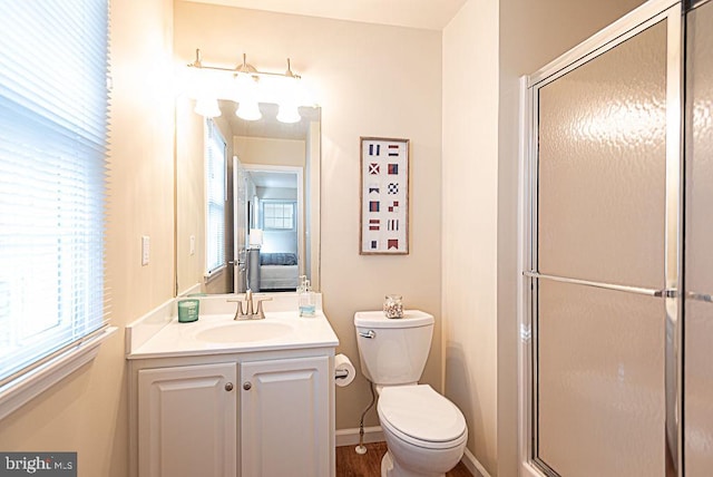 bathroom featuring toilet, vanity, and an enclosed shower