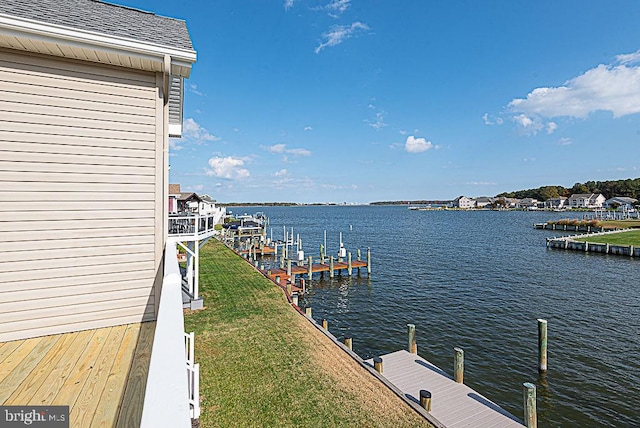 dock area with a yard and a water view