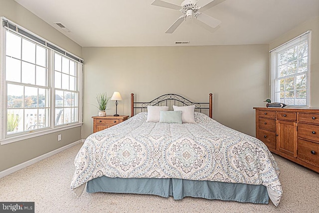 bedroom with light carpet, multiple windows, and ceiling fan