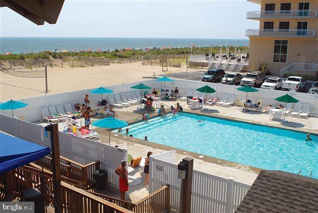 view of pool with a water view and a patio