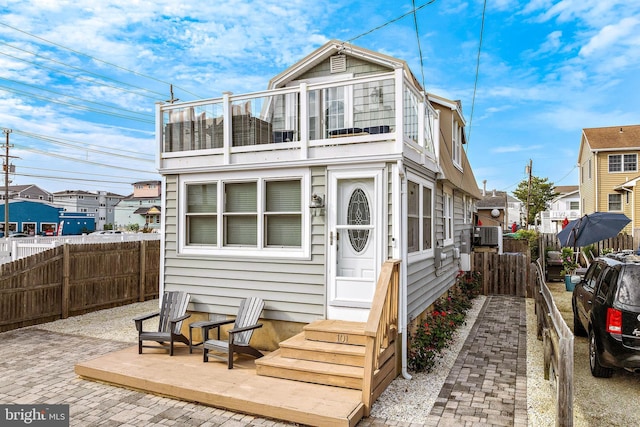 back of property featuring a patio area, fence private yard, and a balcony