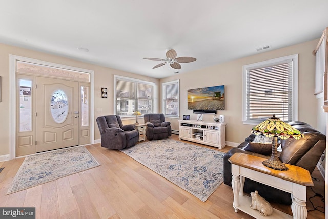 living room featuring ceiling fan, a baseboard radiator, and light wood-type flooring