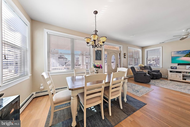 dining area featuring a baseboard radiator, ceiling fan with notable chandelier, and light wood-type flooring