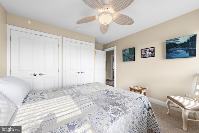 carpeted bedroom with ceiling fan and two closets